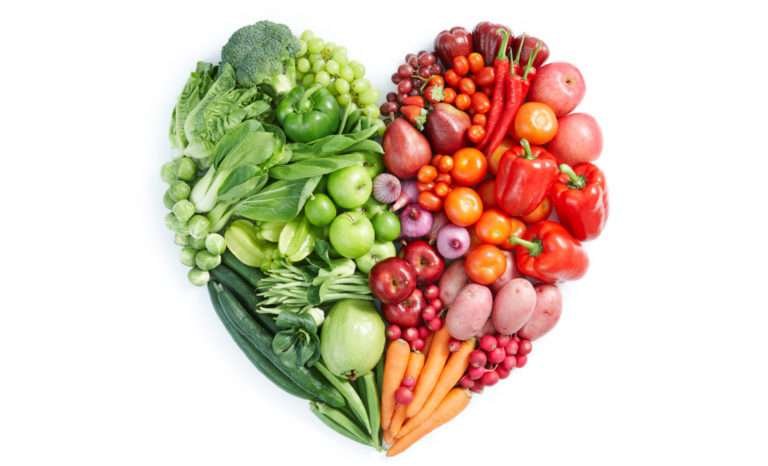 Heart-shaped arrangement of colorful fruit and vegetables, rich in vitamins and minerals.