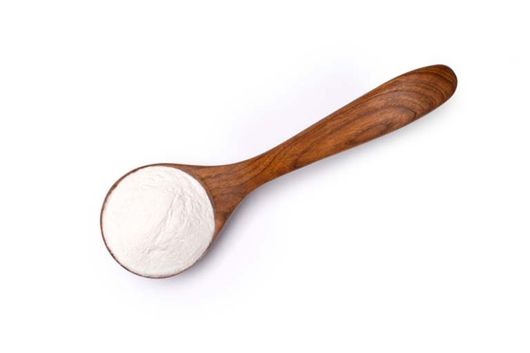 Wooden spoon filled with collagen powder.